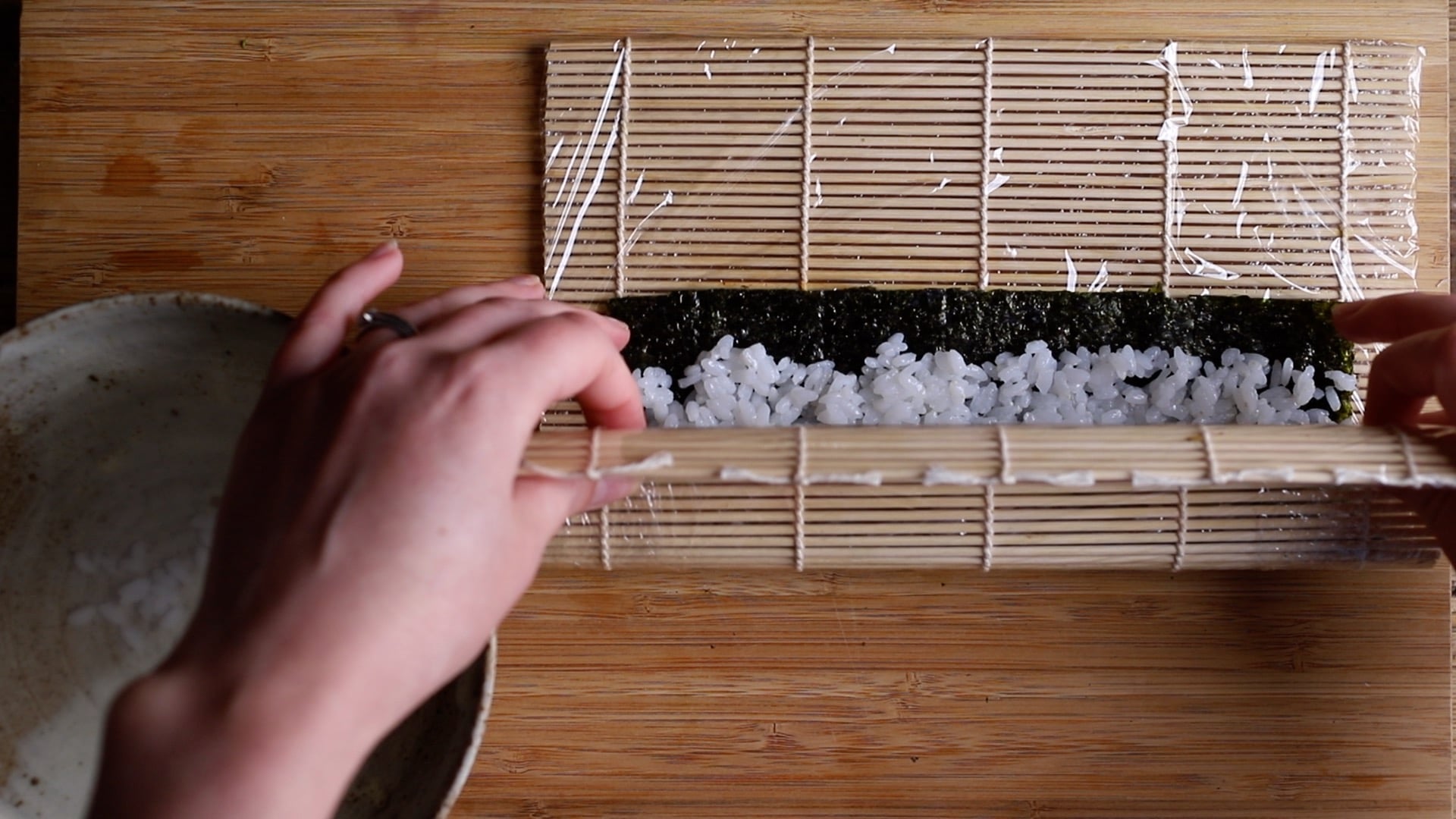 use the bamboo mat to start rolling and folding your maki sushi